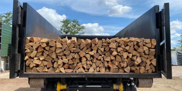 Lots of firewood in the bed of a truck ready to be moved.