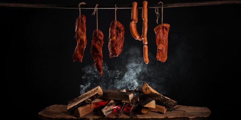 An assortment of smoked meats hangs from the ceiling.
