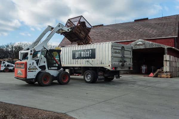 Image of a forklift dumping kiln-dried firewood into a truck at the Lumberjacks Woodstock location.