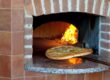 A pizza sliding into a pizza oven