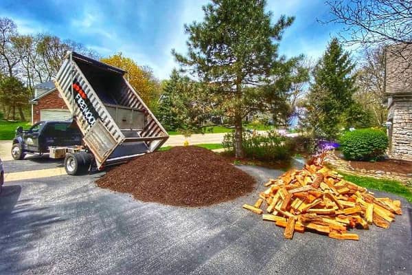 A dump truck from Lumberjacks dropping off mulch and firewood