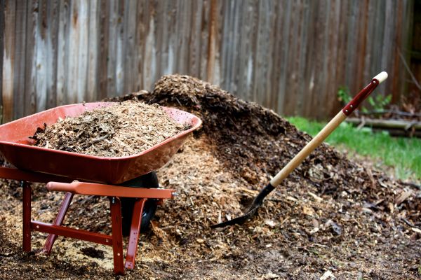 Mulch on a property with a wheelbarrow and shovel