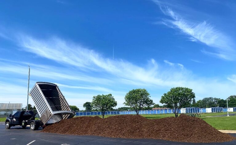 Truck delivering organic mulch in a parking lot