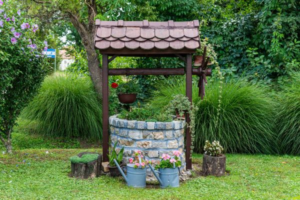 A decorative water well is used as a planter