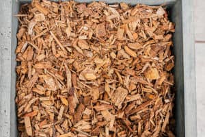 Closeup photo of a bin of hardwood mulch.